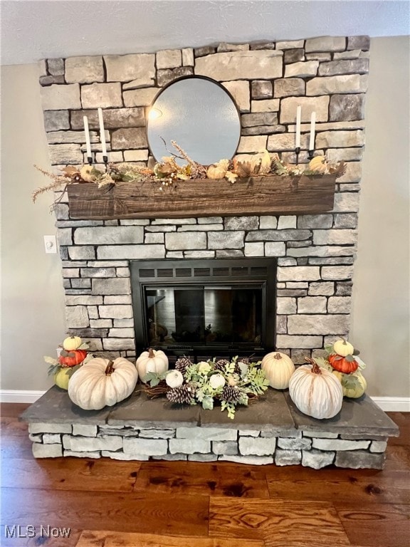 room details featuring hardwood / wood-style flooring and a stone fireplace