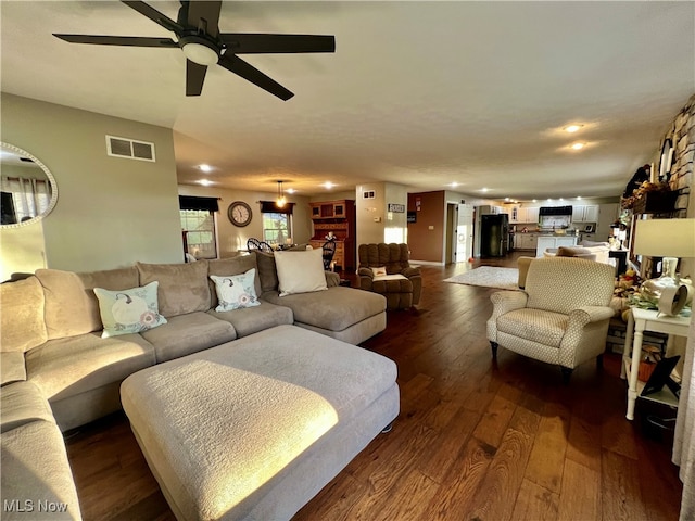 living room featuring ceiling fan and dark hardwood / wood-style flooring