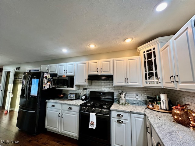 kitchen featuring black appliances, white cabinetry, dark wood-type flooring, and tasteful backsplash