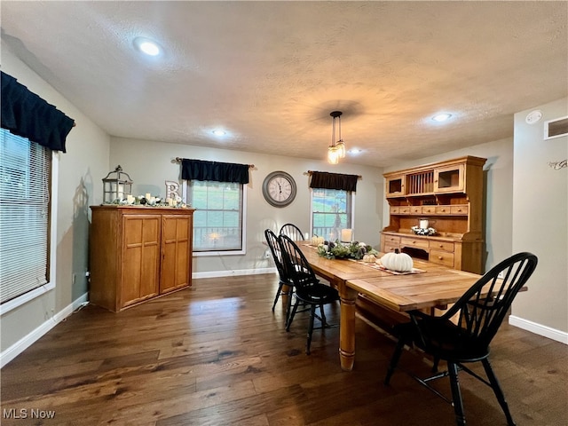 dining area with a textured ceiling and dark hardwood / wood-style floors