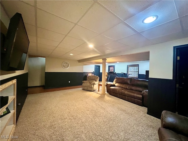 carpeted living room with a paneled ceiling