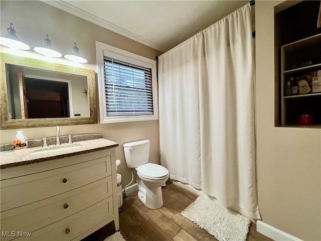 bathroom featuring vanity, toilet, hardwood / wood-style flooring, and ornamental molding