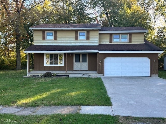 view of property with a garage and a front lawn