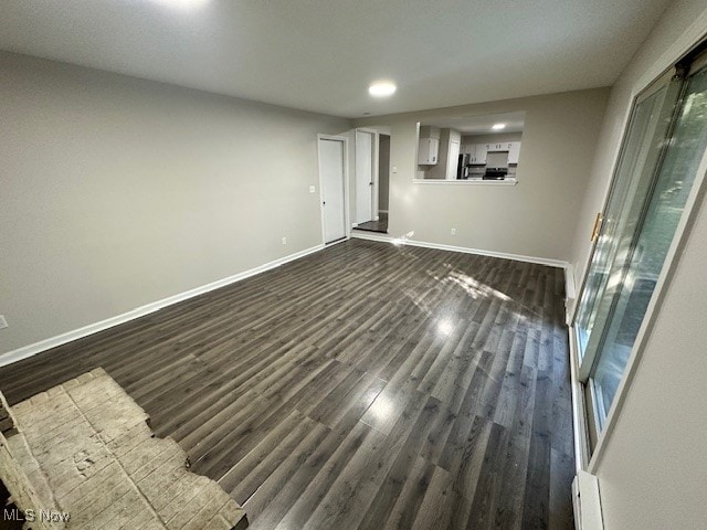 unfurnished room with dark wood-type flooring