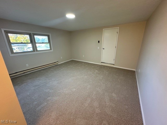 unfurnished room featuring a baseboard radiator and carpet floors