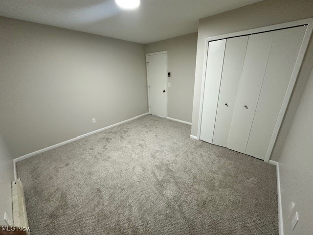 unfurnished bedroom featuring light carpet and a closet