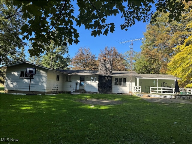 rear view of house featuring a yard