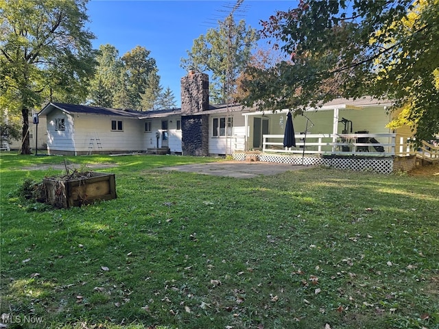 rear view of house featuring a yard