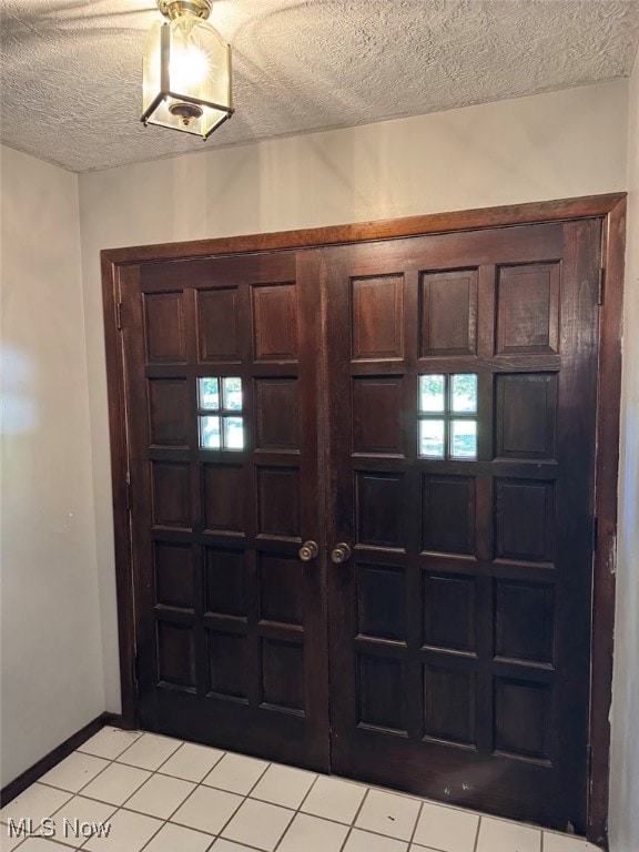 entryway featuring a textured ceiling and light tile patterned flooring