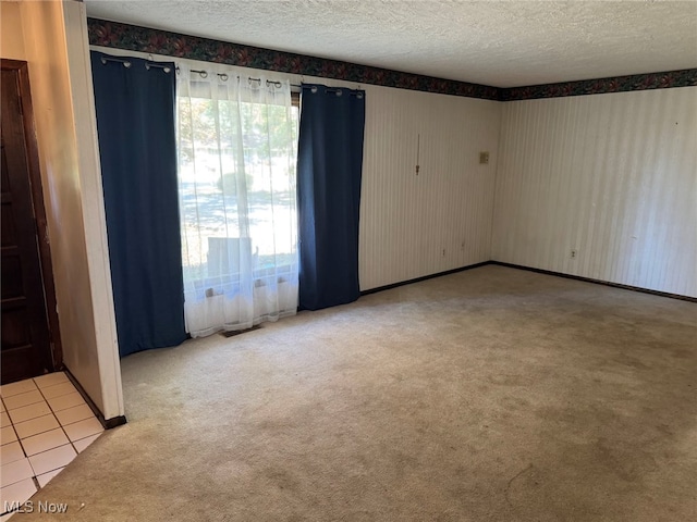 unfurnished room with a textured ceiling and carpet floors