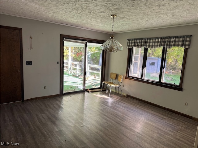 unfurnished dining area with a notable chandelier, a textured ceiling, a wealth of natural light, and dark hardwood / wood-style flooring