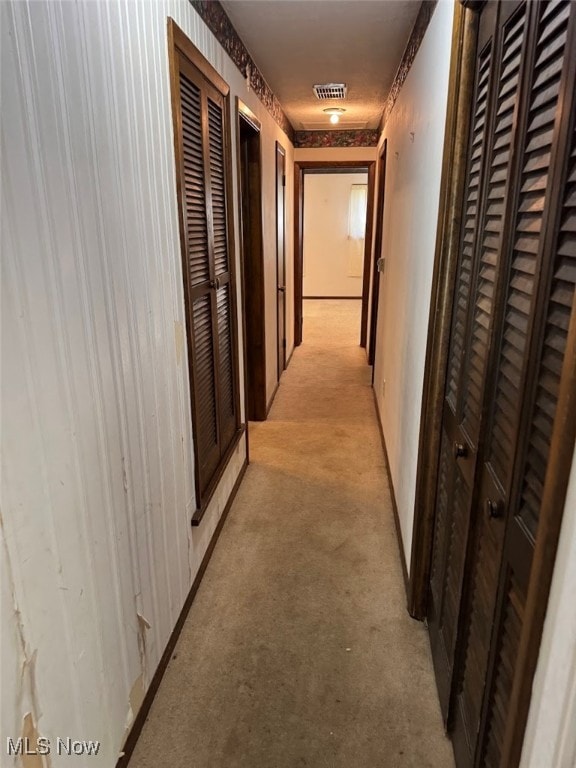 hall with light colored carpet