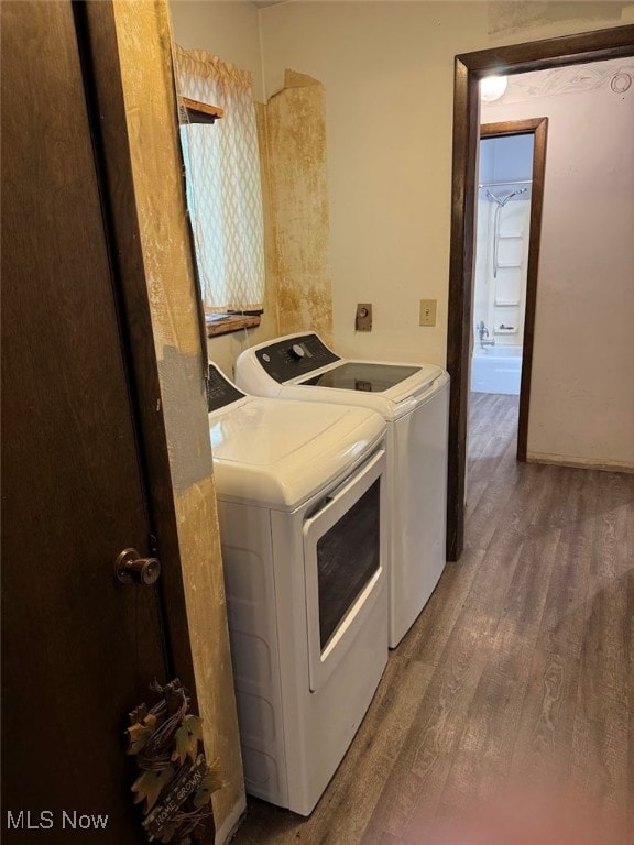 clothes washing area with dark hardwood / wood-style flooring and washing machine and clothes dryer