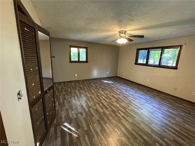 unfurnished bedroom featuring dark wood-type flooring, ceiling fan, and a textured ceiling