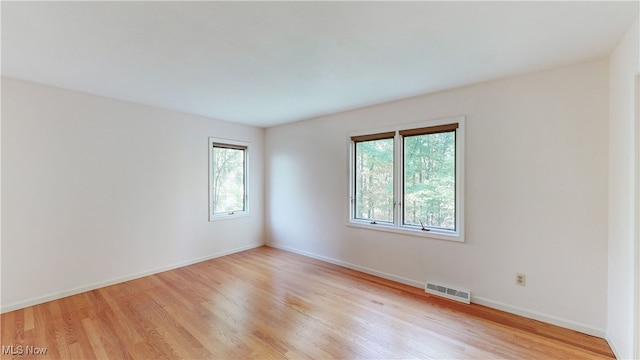 empty room with light hardwood / wood-style flooring and a healthy amount of sunlight