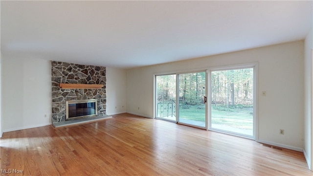 unfurnished living room featuring a fireplace and light hardwood / wood-style floors