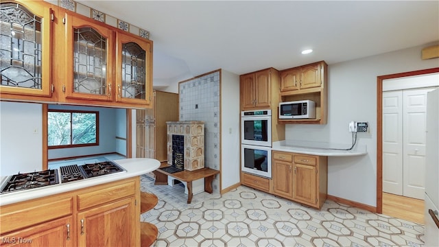 kitchen featuring multiple ovens and stainless steel gas stovetop