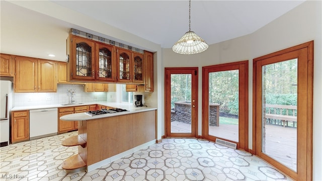 kitchen featuring a notable chandelier, decorative light fixtures, a wealth of natural light, and white appliances