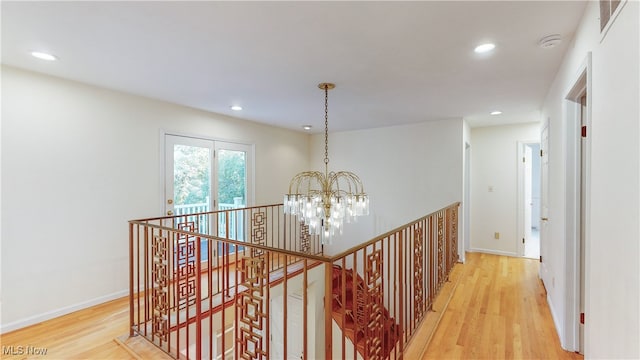 hallway featuring light hardwood / wood-style flooring and a chandelier