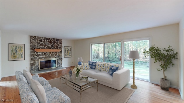 living room with a fireplace and light wood-type flooring