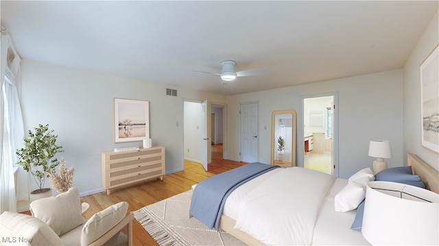 bedroom with light hardwood / wood-style floors, ensuite bath, and ceiling fan