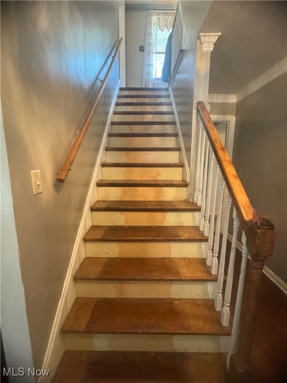 stairway featuring ornamental molding