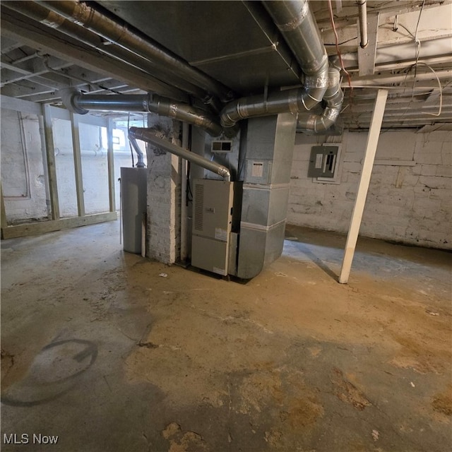 basement featuring heating unit and electric panel