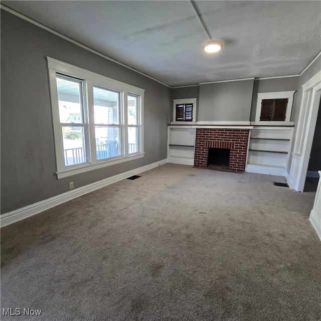 unfurnished living room featuring crown molding, carpet flooring, and a fireplace