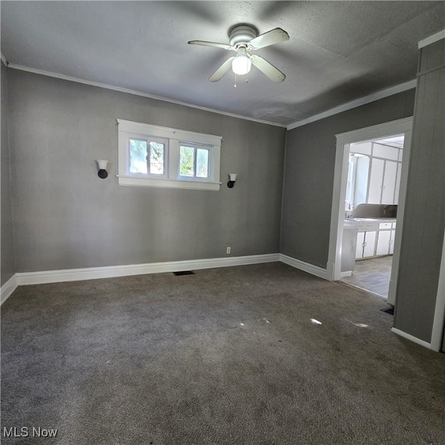 unfurnished room featuring ornamental molding, a textured ceiling, carpet floors, and ceiling fan