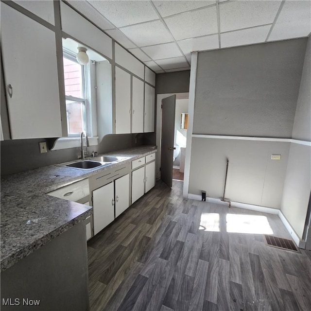 kitchen with a paneled ceiling, sink, dark hardwood / wood-style floors, and white cabinets