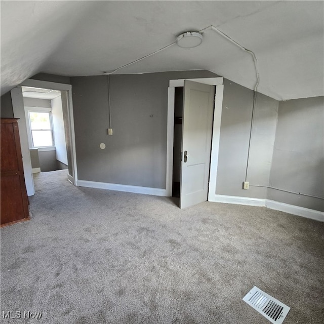 bonus room featuring carpet and vaulted ceiling