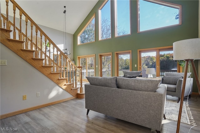 living room featuring a high ceiling, a chandelier, and hardwood / wood-style floors