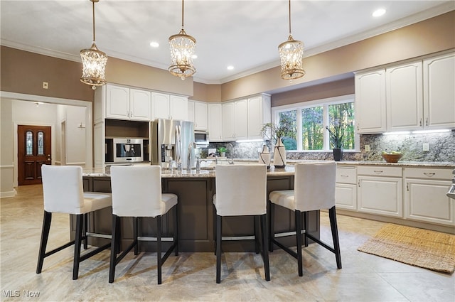 kitchen with white cabinets, light stone counters, backsplash, and an island with sink