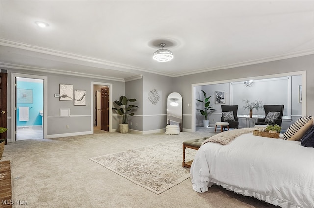 bedroom with crown molding, carpet flooring, and ensuite bath