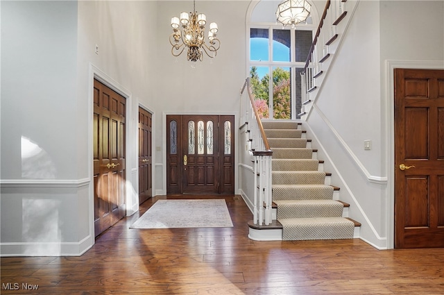 entrance foyer featuring a notable chandelier, wood-type flooring, and a high ceiling