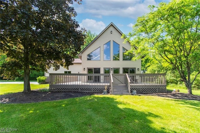 back of property with a deck and a lawn