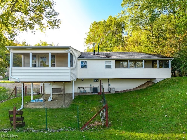 back of property with a patio, central AC, a yard, and a sunroom