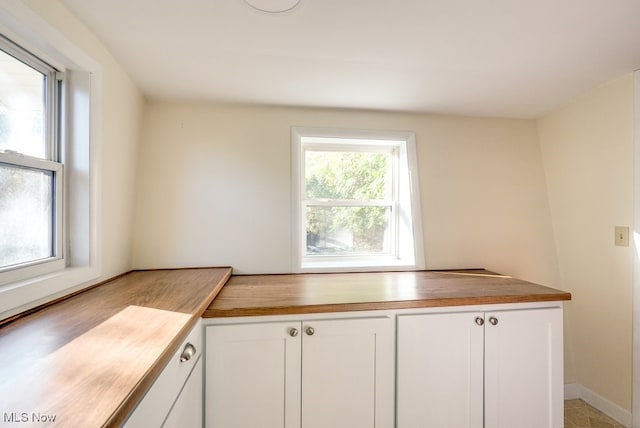 kitchen with wood counters and white cabinets