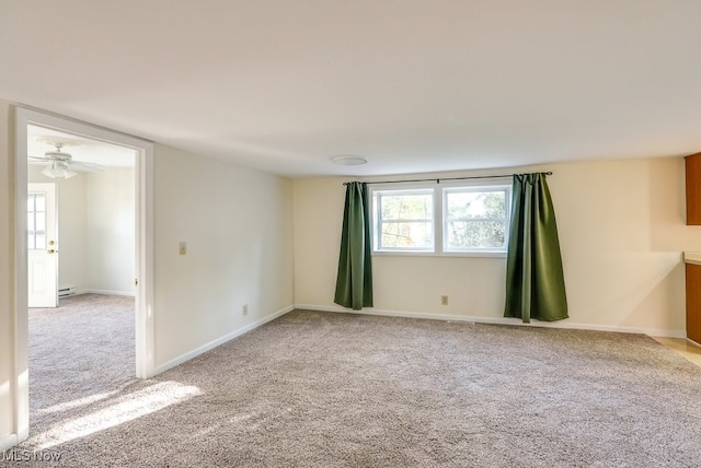 carpeted spare room with baseboard heating and ceiling fan