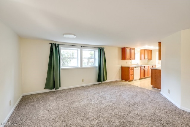 unfurnished living room with light carpet and sink