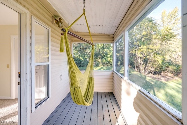 unfurnished sunroom featuring a healthy amount of sunlight and wooden ceiling