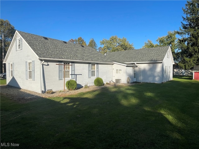 rear view of house featuring a lawn and central air condition unit