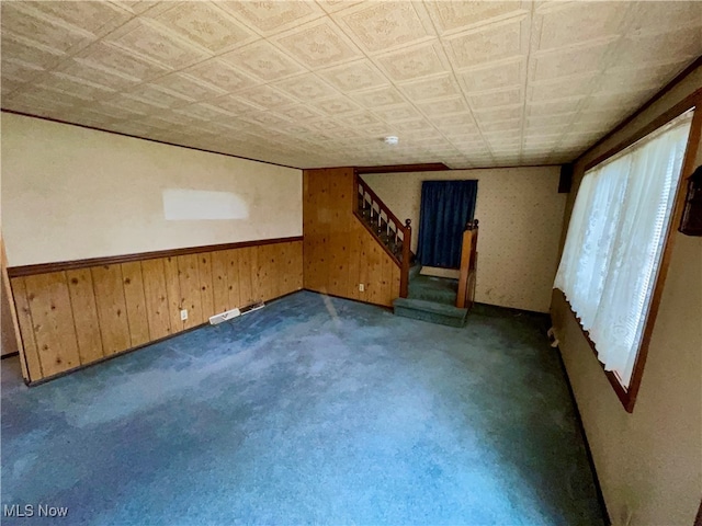 interior space featuring dark carpet and wood walls