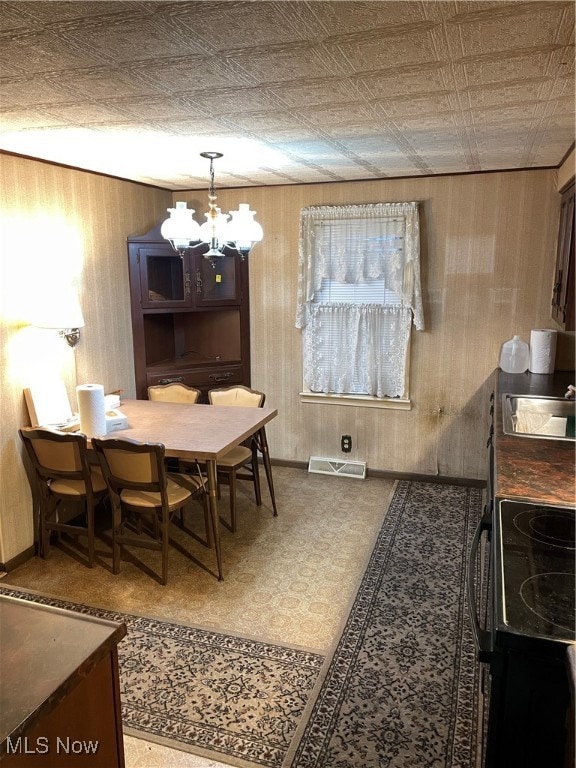 dining area featuring sink and a chandelier