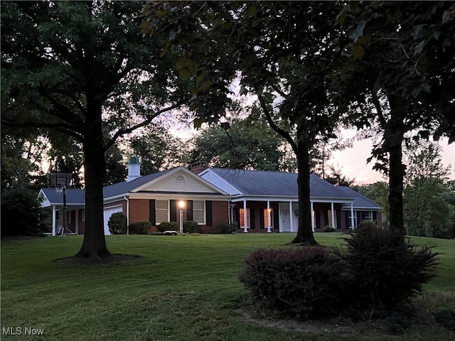 single story home featuring covered porch and a lawn