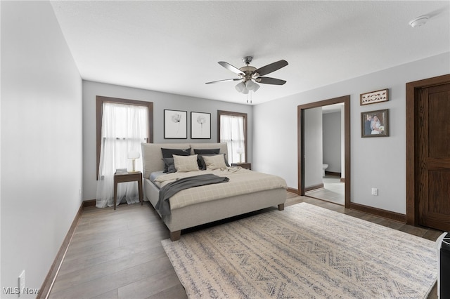 bedroom with ceiling fan, a textured ceiling, multiple windows, and hardwood / wood-style floors