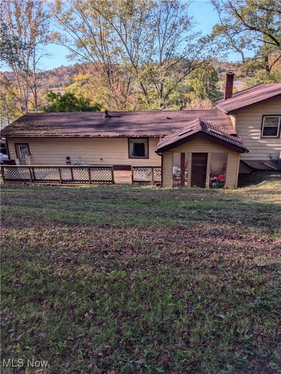 rear view of property featuring a lawn