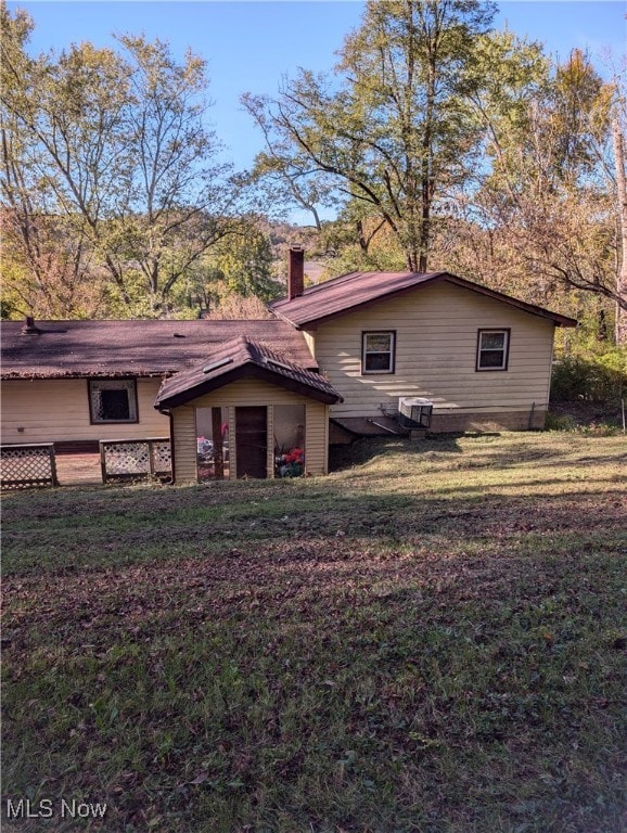 rear view of property featuring a lawn