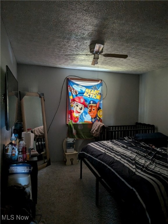 bedroom with ceiling fan, carpet, and a textured ceiling