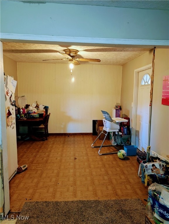 dining area featuring parquet flooring, a textured ceiling, and ceiling fan